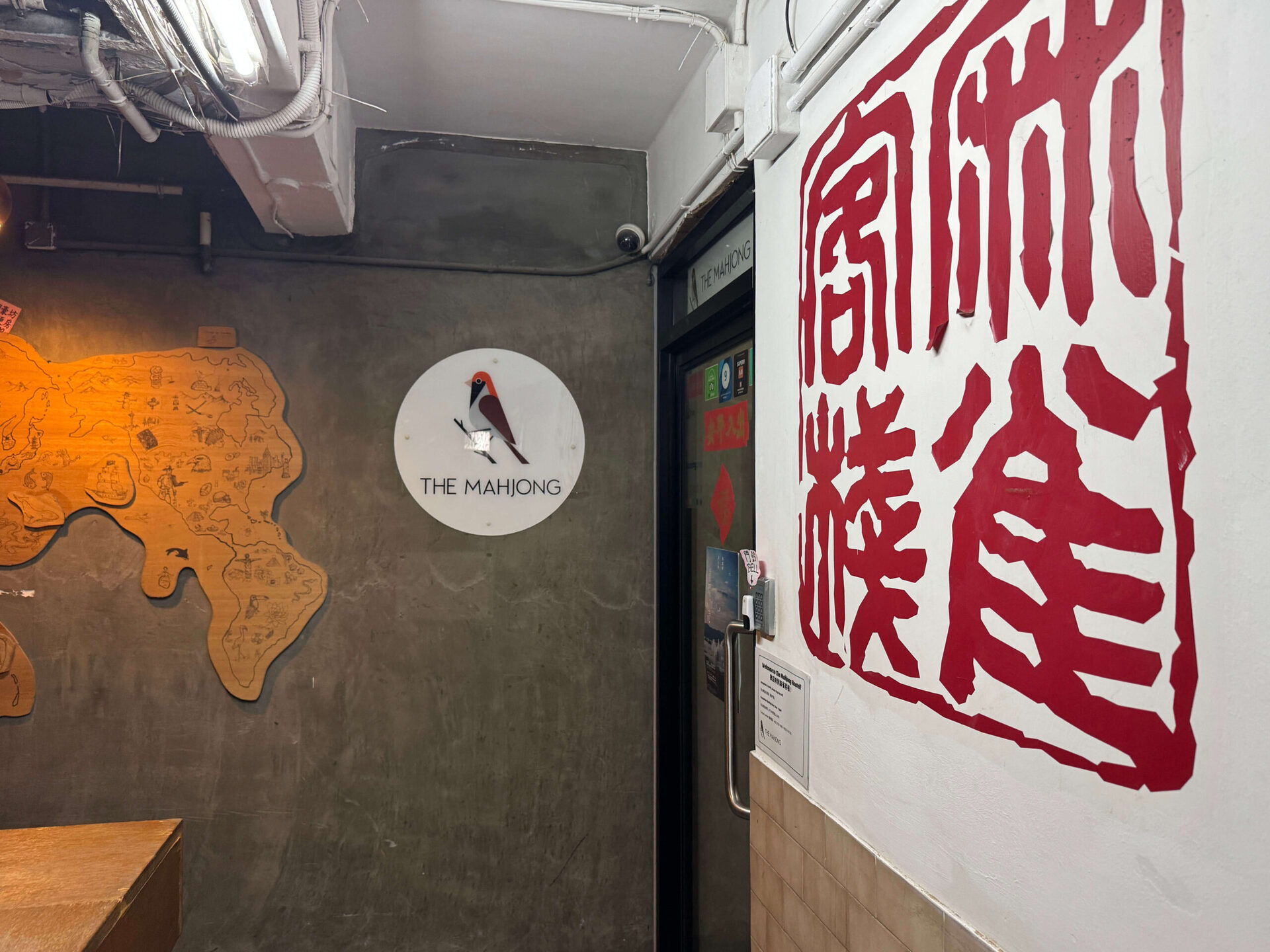 香港麻雀客棧入口品牌LOGO與紅色麻雀印章塗鴉牆