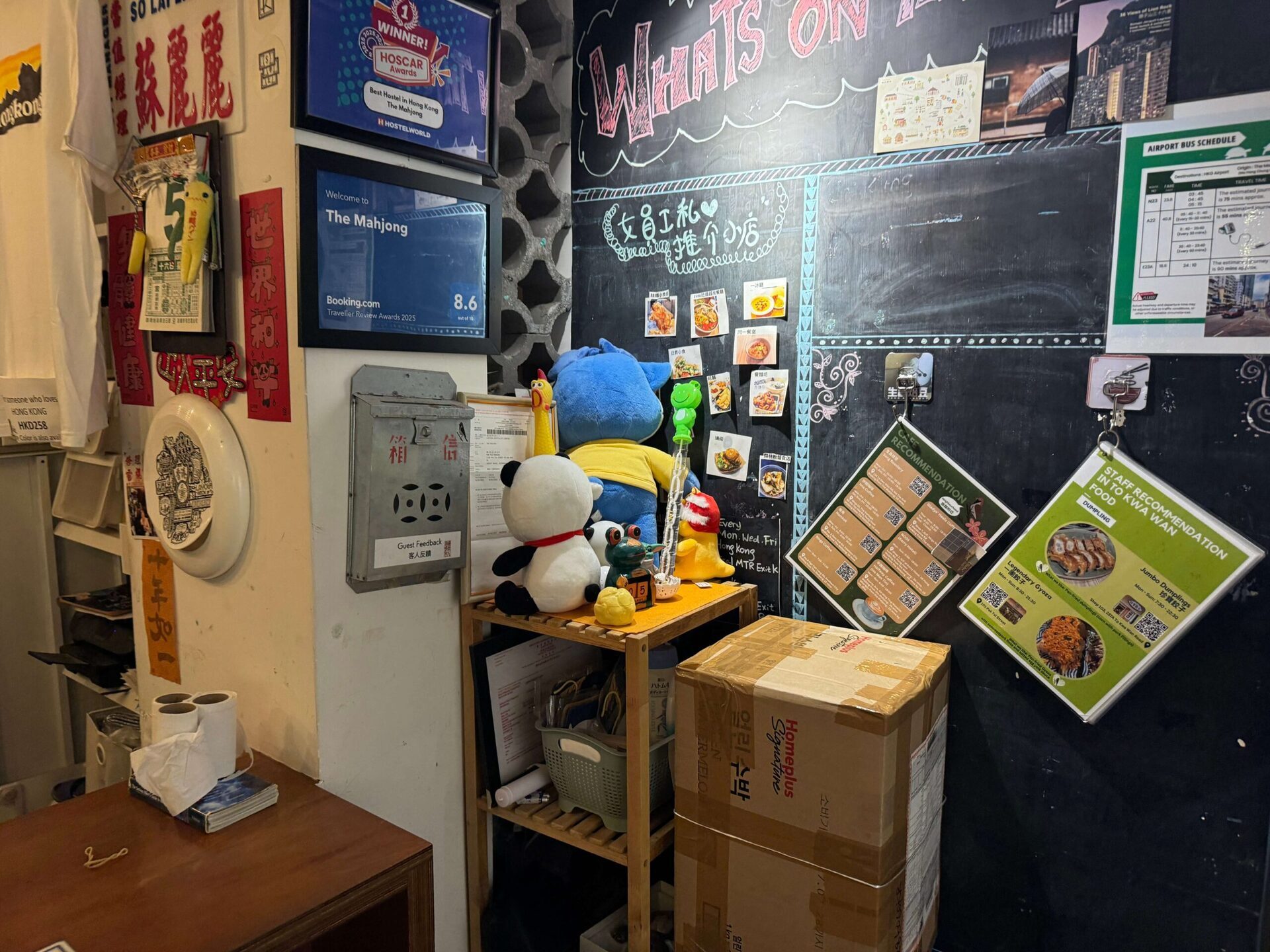 香港麻雀客棧接待櫃台一角玩偶與黑板裝飾