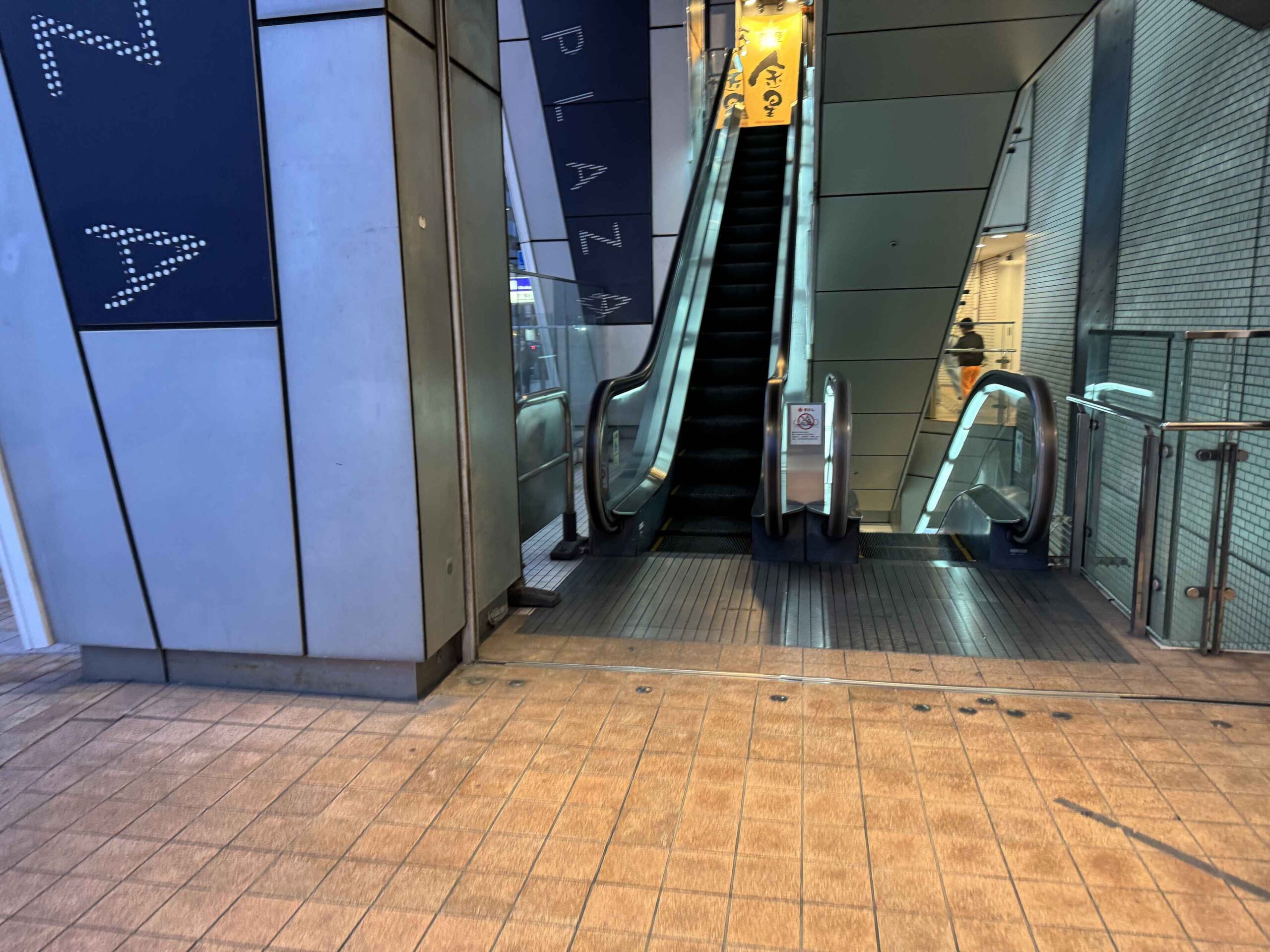 四ツ橋駅出入口，大阪Metro四ツ橋線標誌與日能研補習班招牌，大阪微笑飯店就在出站後步行範圍內