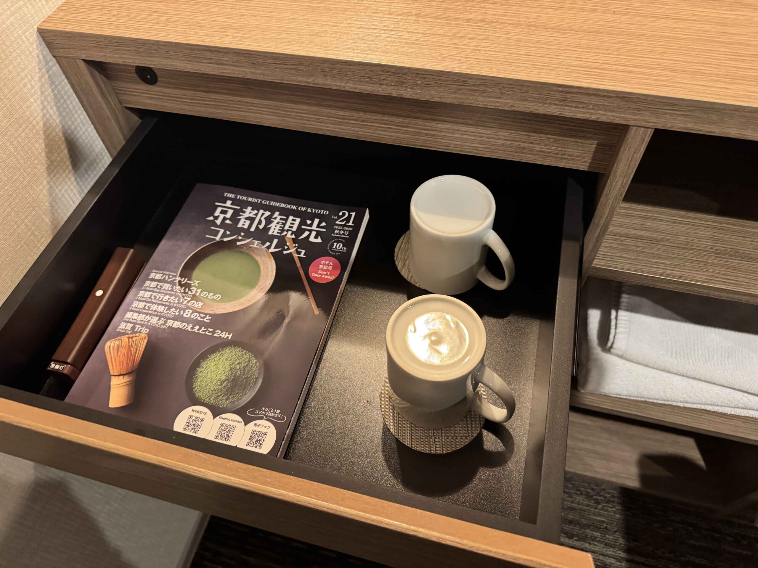 KOKO HOTEL京都三條房間書桌抽屜內附京都觀光指南雜誌、白色瓷杯與抹茶用茶筅