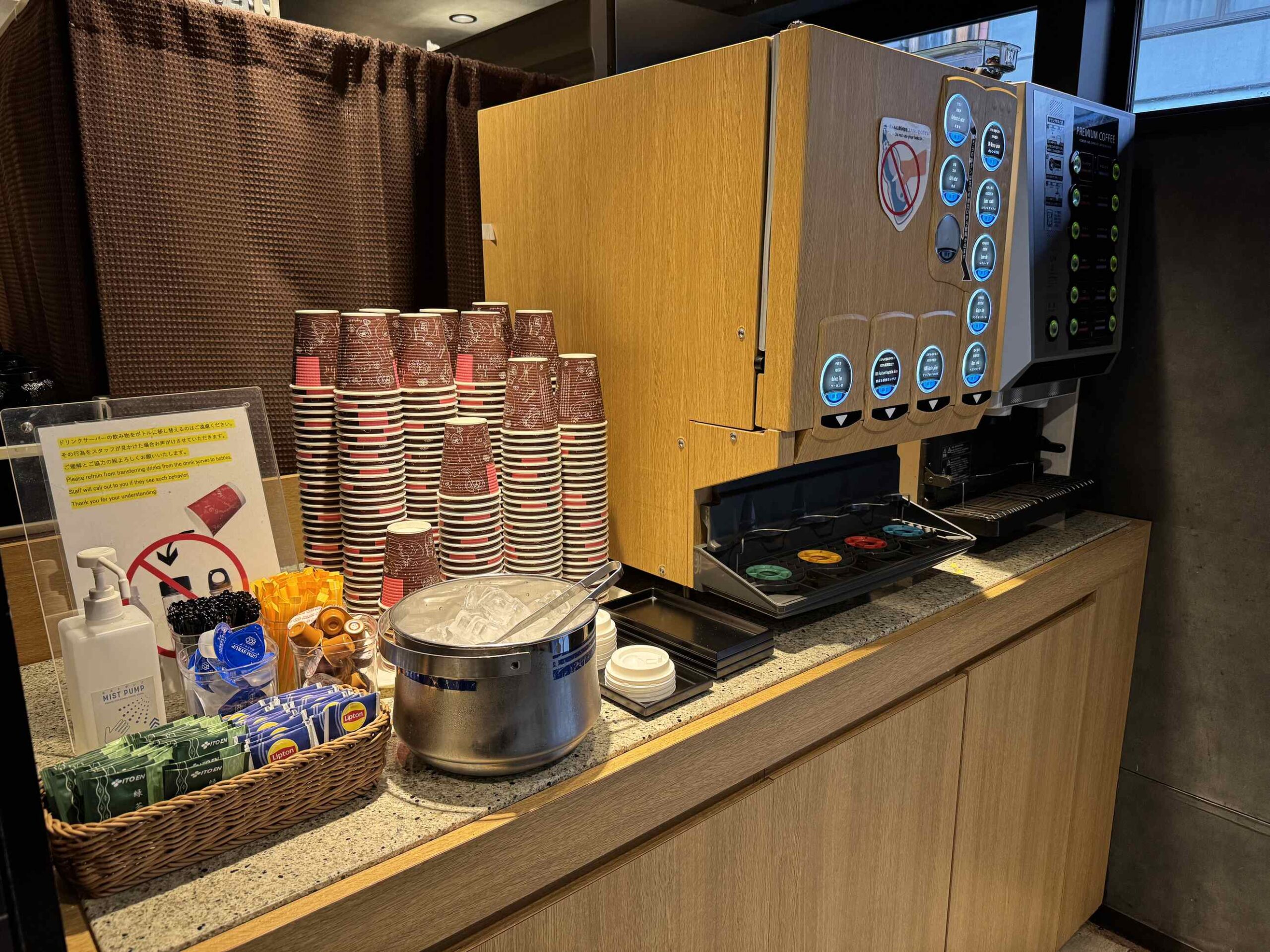 KOKO HOTEL京都三條大廳免費自助咖啡軟飲機，紙杯堆與飲料按鈕及附贈小餅乾