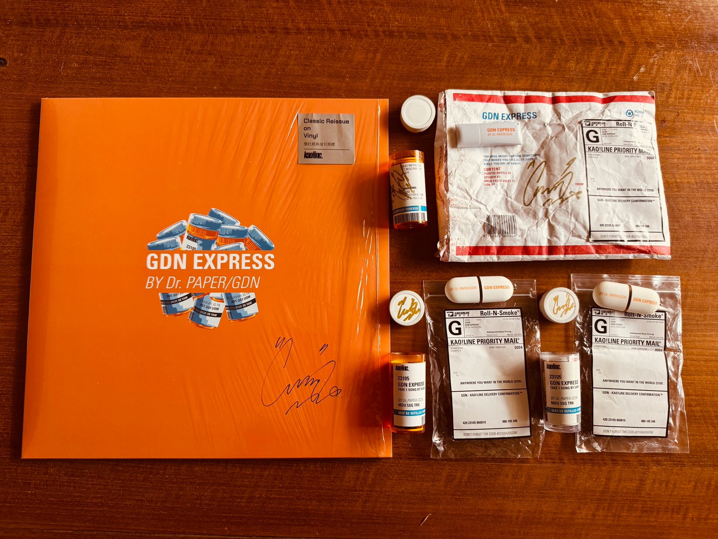 GDN EXPRESS四種版本合照，橘色彩膠封套、快遞袋、藥罐與USB都有簽名